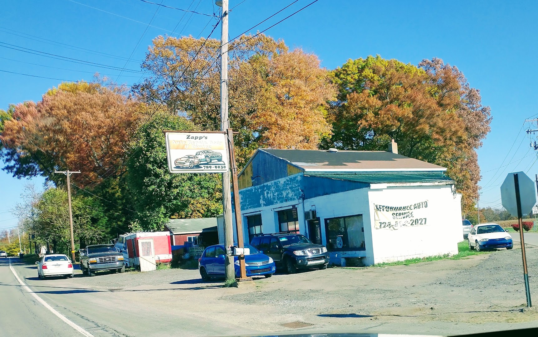 Affordable Auto Services shop exterior with vehicles in front on a sunny day